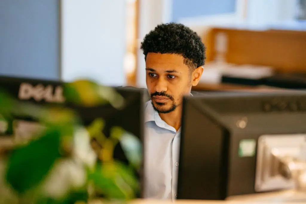A male staff member looking at a computer monitor.