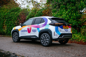 A car with the Be One Homes Careline branding.