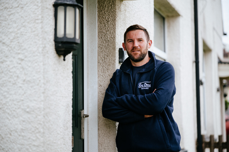 Male repairs operative stood outside the front door of a Be One Homes property.
