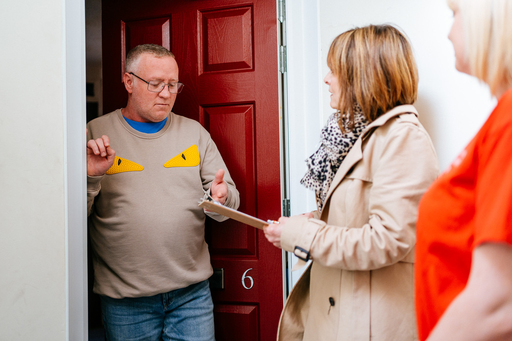 Our CEO, Noel Sharpe, speaks to a customer at his front door. Noel is holding a clipboard to record customer feedback.