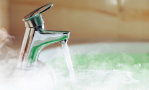 A running tap with steamy hot water beneath.