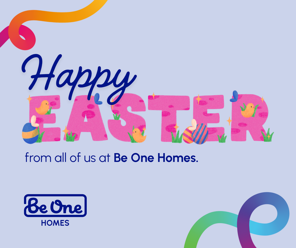 A colourful Easter greeting graphic featuring the words “Happy Easter from all of us at Be One Homes.” The word “EASTER” is decorated with chicks, Easter eggs, grass, butterflies, and sparkles. Curved multicoloured ribbon shapes frame the corners, and the Be One Homes logo appears below the message.