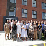 Kirith Entwistle MP stands with colleagues from Be One Homes and Irwell Valley Homes, partners, customers and board members outside a newly developed apartment building.