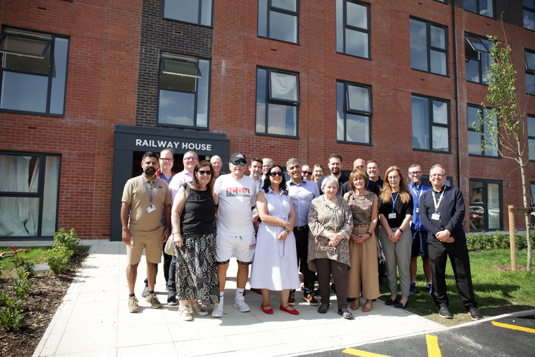 Kirith Entwistle MP stands with colleagues from Be One Homes and Irwell Valley Homes, partners, customers and board members outside a newly developed apartment building.