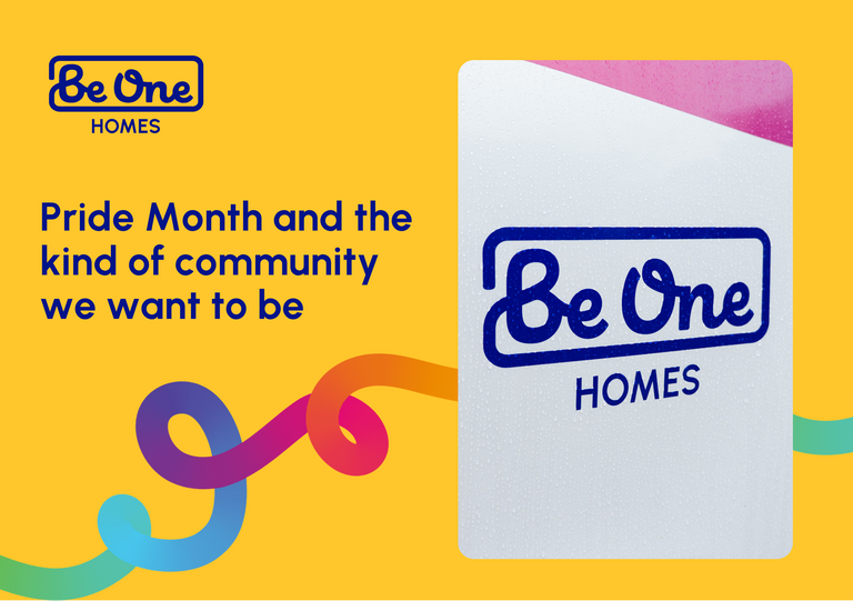 Bright, graphic promotional image for Be One Homes set on a bold yellow background. In the top left, a blue “Be One Homes” logo appears, with “Be One” in a rounded handwritten-style font inside a rectangular outline and “HOMES” in uppercase below. Large dark-blue text on the left reads: “Pride Month and the kind of community we want to be.” On the right, there is a rounded-corner photo showing a close-up of a “Be One Homes” sign featuring a diagonal pink section at the top.