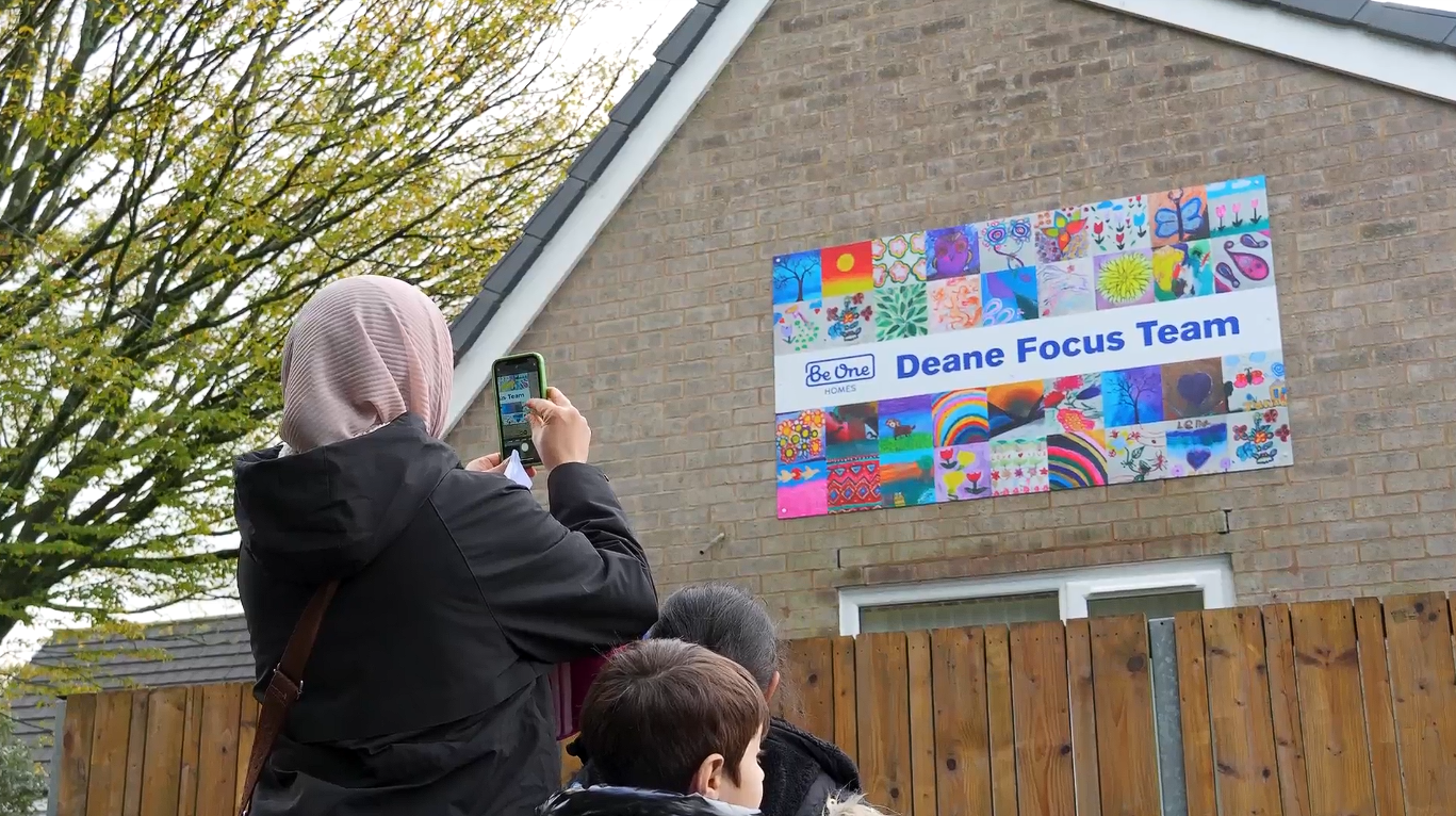 A local resident using her smartphone to take a photo of the Deane Focus Team signage.